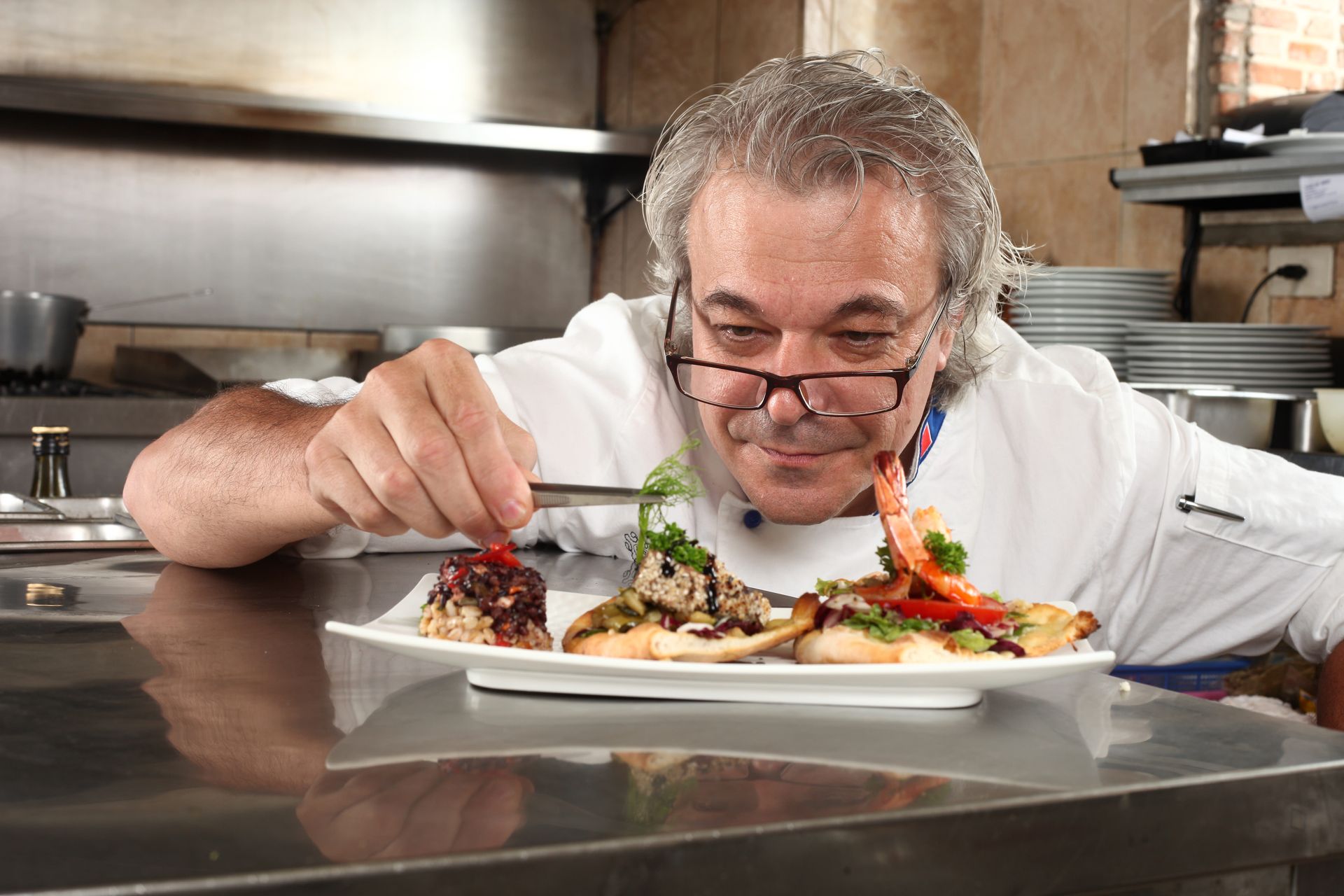 Chef Paolo Nesi putting the finishing touches on a dish